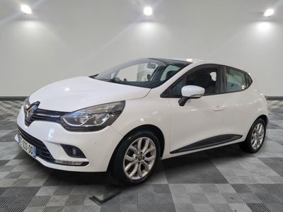une voiture blanche est garée dans une pièce au sol à carreaux