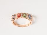 gros plan d'une bague en or avec des pierres multicolores