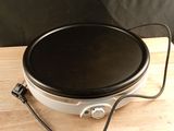 a crock pot on a wooden table with a black cover