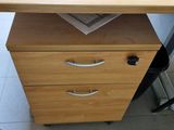 a desk with a file cabinet and a chair in front of it
