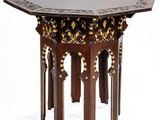 une petite table avec un plateau noir et des décorations dorées
