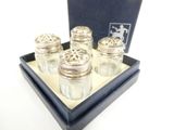 four salt and pepper shakers in a blue box