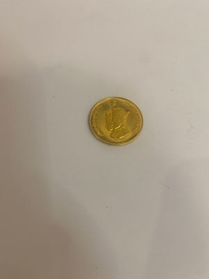 gros plan d'une pièce d'or sur une surface blanche