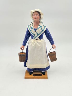 figurine of a woman in a blue dress holding a bucket and a basket