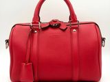 a red leather handbag with a tag on it