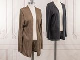 two mannequins in front of a white wall and a brown and black jacket on a mannequin stand