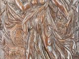 an image of a bronze plaque with a woman holding a fan