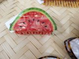 a piece of watermelon sitting on the floor next to a comb