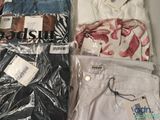several pairs of jeans are packed in plastic bags on a table
