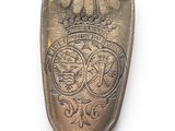 a silver spoon with a crown on it on a white surface