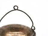 a small metal bowl with a handle on a white surface