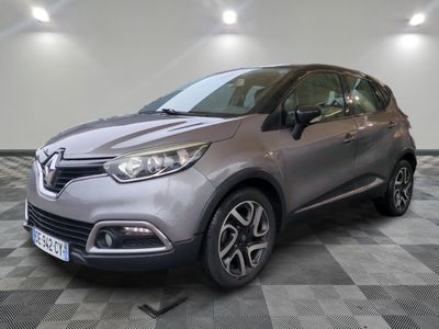 the grey car is parked on a checkered floor in a garage