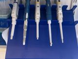 a blue tray with five different types of thermometers on it