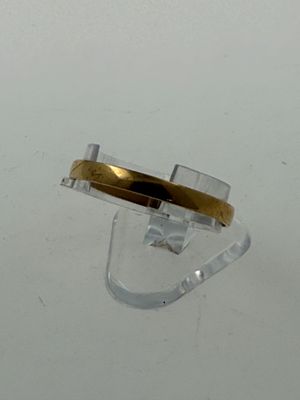 a ring with a gold band sitting on top of a clear object
