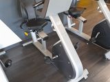 two stationary exercise bikes in a gym with a yellow wall
