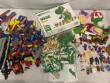 un tas de Lego sur un lit, avec une boîte de Lego