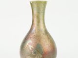 a green vase with a bird on it on a white background