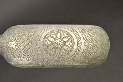 une bouteille en verre décorée, posée sur une table