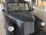an old black car in a garage with a sign on it