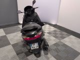 a man sitting on a motor scooter in a room with a checkered floor