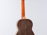 a close up of a guitar hanging from a string on a wall