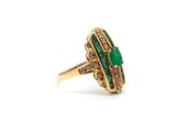 a close up of a gold ring with a green stone