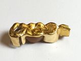 a close up of a gold plated object on a white surface