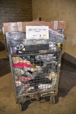 un chariot rempli de chaussures, surmonté d'une pancarte