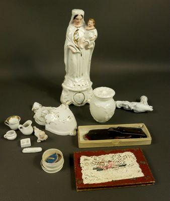 a statue of a woman holding a child next to other items