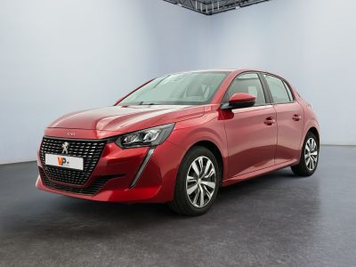 Une voiture rouge est garée dans une pièce blanche au sol noir.
