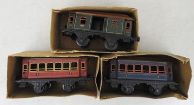 three toy trains sitting in a box on a white surface