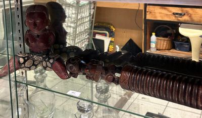 une vitrine en verre sur laquelle sont posés deux masques en bois