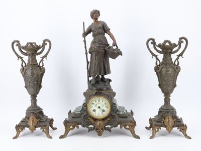 trois statues en bronze représentant une femme et deux vases accompagnés d'une horloge