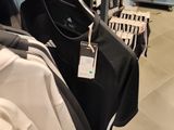 a lot of shirts hanging on the rack in the store