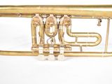 a brass trumpet that is sitting on a white surface
