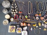 a lot of jewelry on a table with a black table cloth