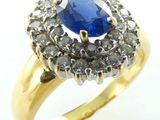 gros plan d'une bague avec une pierre bleue entourée de diamants