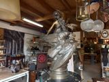 a statue of a woman sitting on a pedestal in a shop