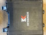 a black case with a red m logo on it next to other tools