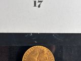 a close up of a gold coin on a black surface