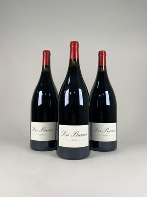 three bottles of red wine sitting on top of a table
