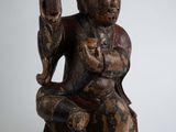 une image représentant une statue en bois d'un homme tenant un pistolet