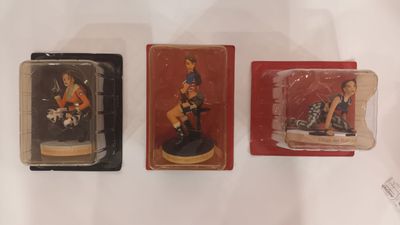 three miniature figurines of a woman on a motorcycle