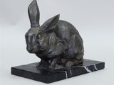 statue of a rabbit on a marble base on a white background