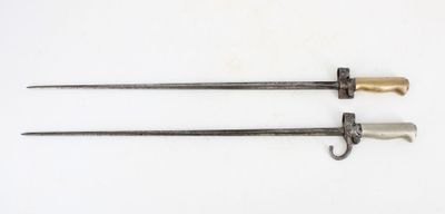 pair of old swords on a white surface with a white background