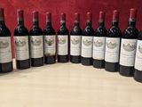 six bouteilles de vin rouge sont alignées sur une table