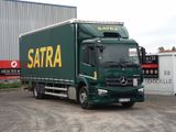 un camion vert garé devant un immeuble