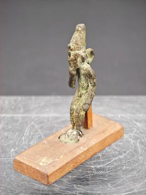 une image représentant une statue de femme tenant un oiseau sur un socle en bois