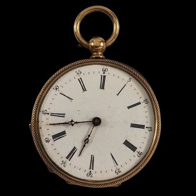 une montre de poche en or avec des chiffres romains sur le cadran