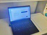 a laptop computer sitting on a desk in front of a tv